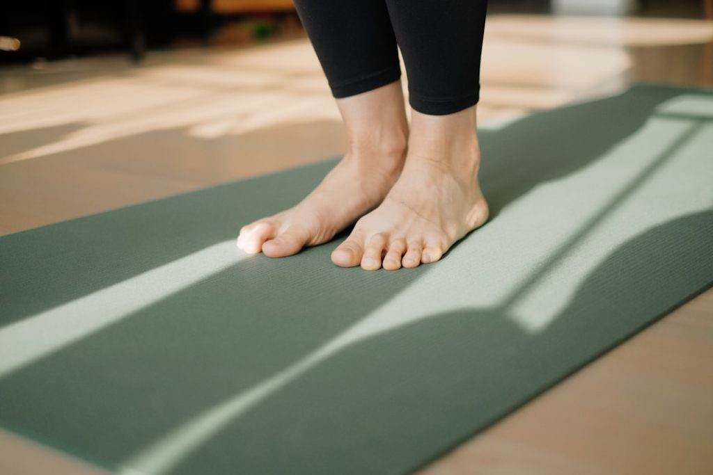 a-person-standing-on-a-yoga-mat-on-the-floor-g9h5edul0t8